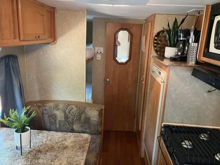 Step inside this cozy RV rental, featuring a dining booth, kitchen with stove and microwave, plus bunk beds.. Gulf Stream Ameri-Lite 25 BS 2008