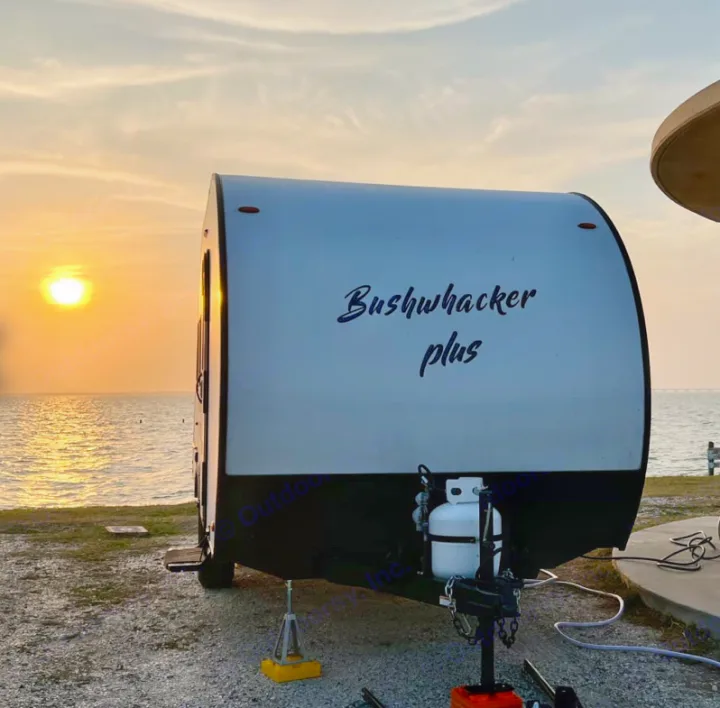 Bushwhacker Plus RV rental at sunset. This travel trailer offers peaceful waterfront camping views.. Braxton Creek BUSHWHACKER PLUS 17FD 2022