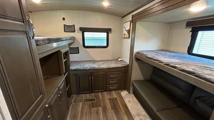 Cozy RV rental bunkhouse: multi-level beds, built-in storage, and a window. Ideal for family travel accommodations.. Keystone Cougar Half-ton 2022