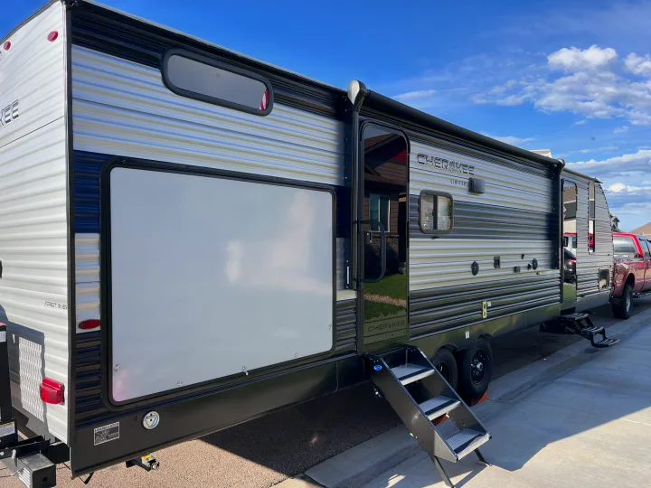 Black and gray striped travel trailer with deployed steps, ready for your next RV rental adventure.. Forest River Cherokee 2022