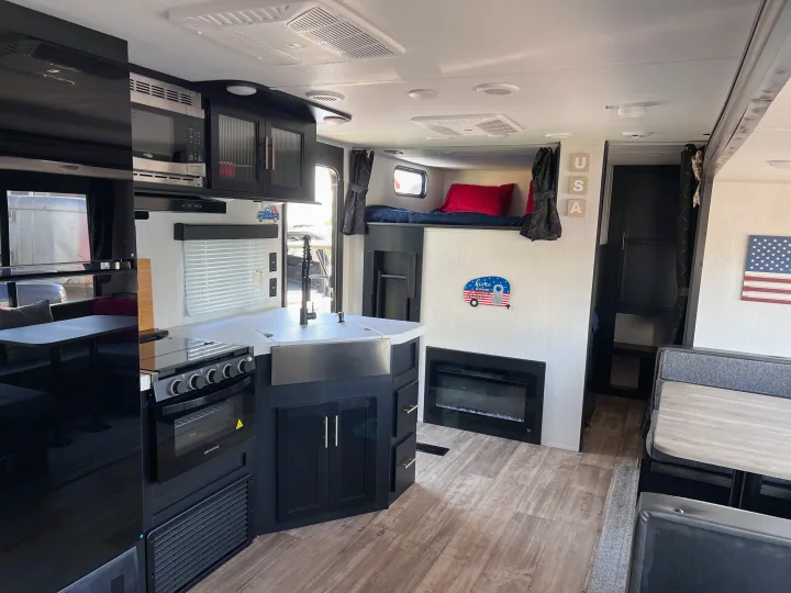RV rental interior featuring a well-equipped kitchen, bunk beds, fireplace, and dining area for comfortable travel.. Forest River Cherokee 2022