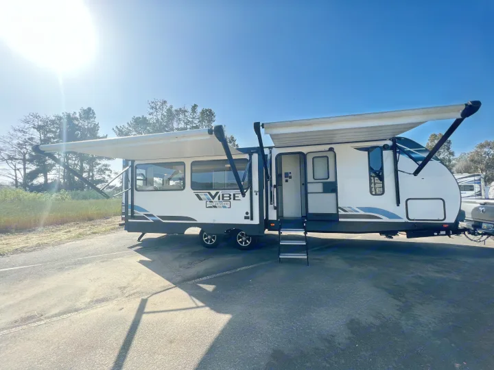 Spacious VIBE travel trailer RV rental, parked with awnings extended and steps down on a sunny day.. Forest River Vibe 2022