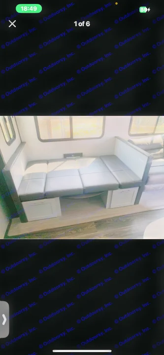 A clean RV rental interior features a convertible dinette with dark cushions, under-seat storage, and large windows.. Forest River Vibe 2022