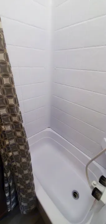 Essential RV rental amenity: a clean, compact white shower stall with a patterned curtain and visible drain.. Jayco Flight 2020