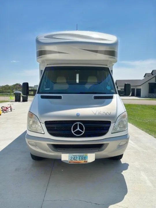 Front view of a silver Mercedes-Benz Sprinter View RV rental. North Dakota plate 242 EBX, ready for adventure.. Winnebago View 2011