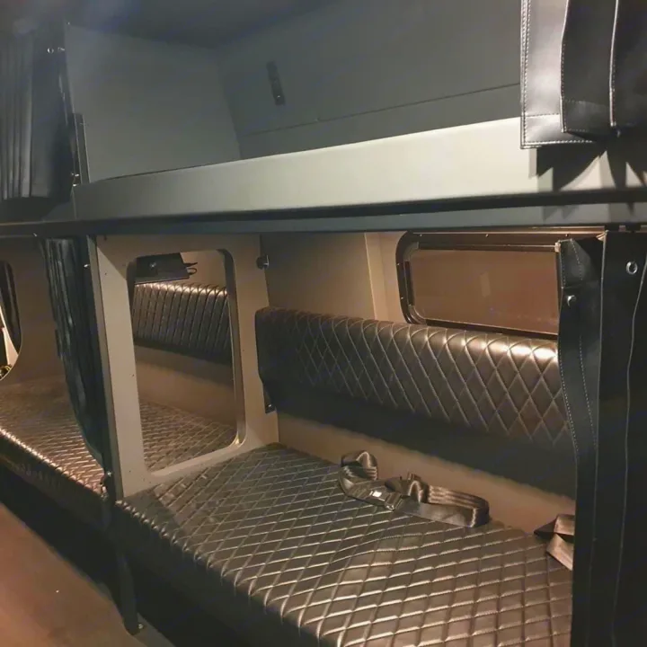 Spacious RV rental interior with comfortable diamond-quilted bunk beds and seating for road trips. Perfect for travel.. Mercedes Sprinter Freight Liner 2020