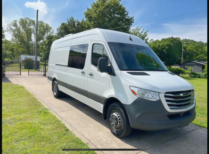 White Mercedes-Benz Sprinter camper van for RV rental, parked on a sunny driveway with trees and sky.. Mercedes Sprinter Freight Liner 2020