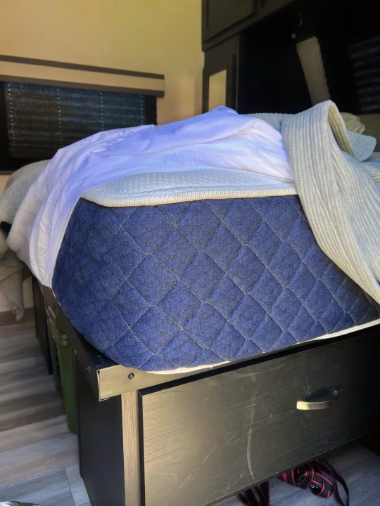 RV rental sleeping comfort: A blue quilted mattress with white bedding and a practical storage drawer below.. Coachmen freedom express 287bhds 2022