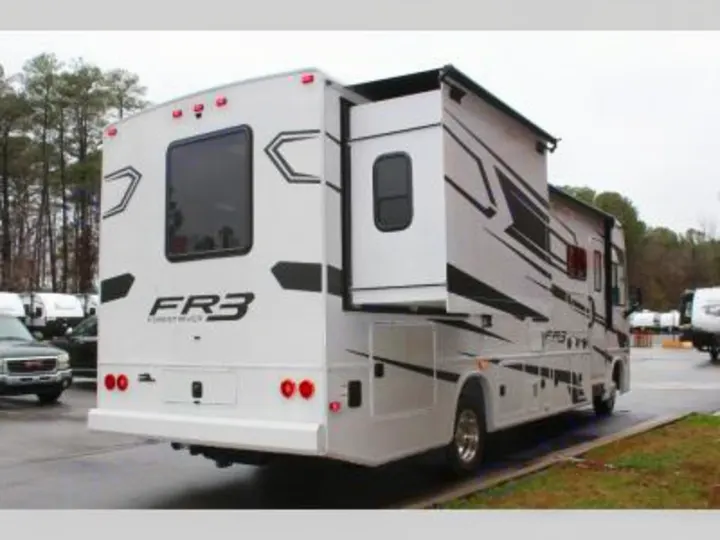 This white Forest River FR3 motorhome, featuring black graphics and an extended slide-out, is an excellent rv rental option.. Forest River FR3 30DS 2023