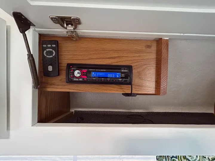 RV rental overhead cabinet with Sony stereo (FM 88.3) and remote, showcasing interior entertainment system.. Airstream Excella 2000