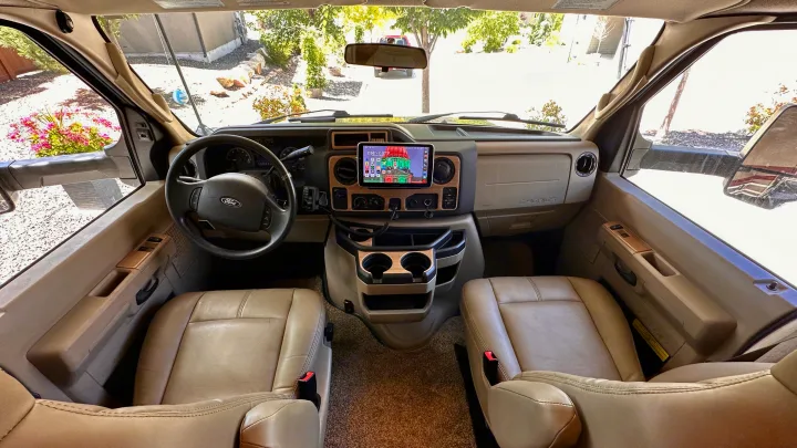 RV rental: Detailed cockpit view with spacious tan seats, Ford dashboard, and large tablet for navigation and infotainment.. Thor Chateau 2018