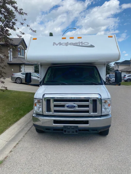 Front view: White Ford Majestic RV rental, a Class C motorhome, parked on a residential street, ready for your next adventure.. Thor Majestic 2018
