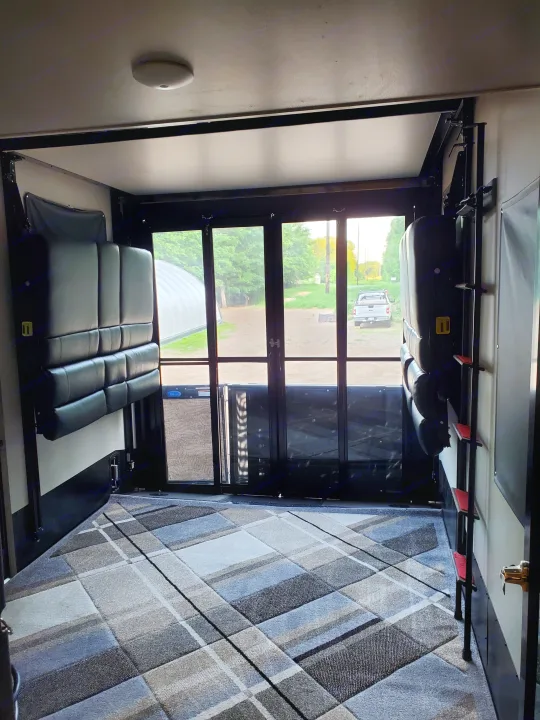 This RV rental's multi-functional interior features power lift beds, patio doors, and an area rug for comfort.. Keystone Raptor 2020