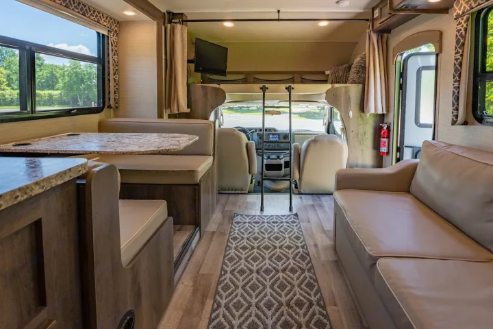 Spacious rv rental interior showing dinette, sofa, and overhead bed. Ready for comfortable road trip adventures.. Jayco Redhawk 2019