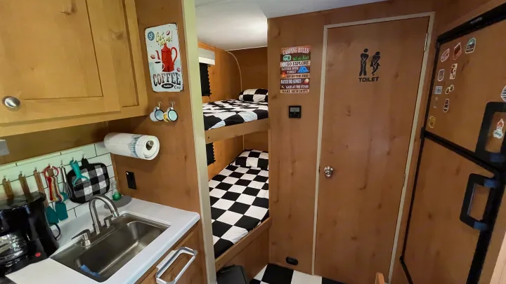 This rv rental offers a compact kitchen, twin bunk beds, and a private toilet. Ideal for small group travel & camping.. Riverside RV Retro 2022