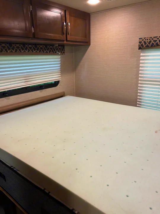 RV rental bedroom with a comfortable bed, foam topper, overhead cabinets, and window blinds.. Jayco Redhawk 2020