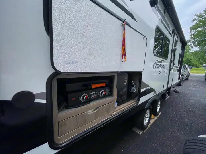 This rv rental travel trailer features an awesome outdoor kitchen with a Blackstone griddle, perfect for camping adventures.. Grand Design Imagine XLS 2022