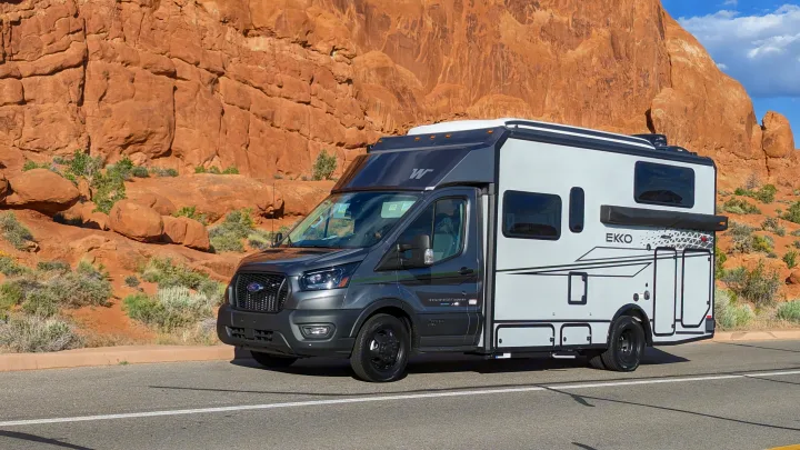 This rv rental, a sleek gray and white camper van, is perfectly suited for a desert road trip in a national park.. Winnebago Ekko 2023