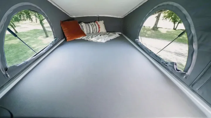 RV rental pop-top bed provides a comfy sleeping space. Arched windows offer expansive outdoor views.. Winnebago Ekko 2023