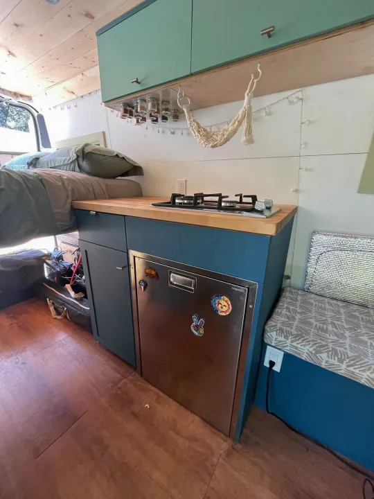 RV rental interior: cozy bed, compact kitchen with stovetop & fridge, and smart storage solutions.. Other Sprinter Van 2017