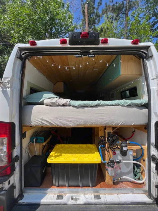 Open back doors of an rv rental conversion van reveal bed, storage, power, and water systems.. Other Sprinter Van 2017