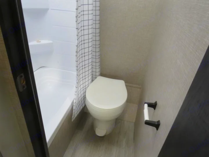 Inside an RV rental bathroom: functional white tub/shower, toilet, and checkered curtain.. Jayco Jay Flight SLX STX Edition 2023