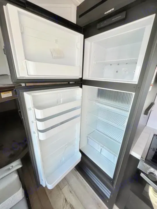 Spacious, clean Dometic fridge/freezer inside an RV rental, ready for your travel provisions.. Keystone RV Springdale 2022