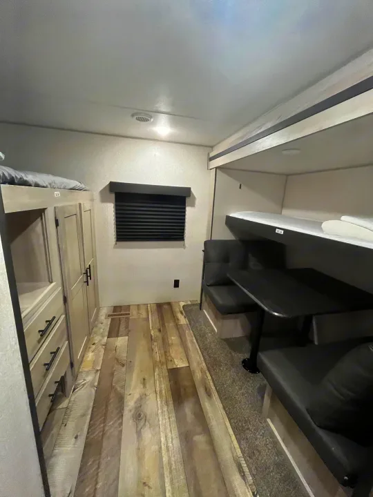 Modern RV rental interior with bunk beds, dinette, and ample storage, providing a compact yet functional travel space.. KZ Connect 2021