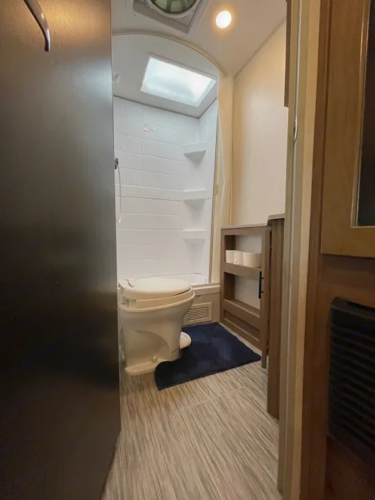 Inside an RV rental: a compact bathroom with a toilet, shower, and storage for essentials.. Forest River No Boundary 2020