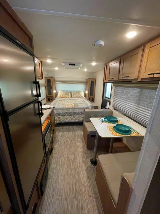 A spacious RV rental interior features a modern kitchen, comfortable dinette, and cozy bedroom, offering a complete living space.. Forest River No Boundary 2020
