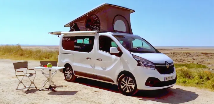 A white pop-top camper van with an awning and outdoor seating set up in a flat, open landscape, ideal for an rv rental.. HANROAD TREK 4 2023