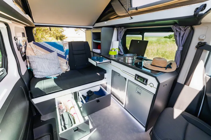 Modern RV rental interior: compact kitchen, lounge seating/bed, and smart storage for your adventures.. HANROAD TREK 4 2023