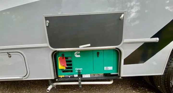 This RV rental displays an open side compartment revealing a green Onan generator, providing onboard power.. Forest River Coachmen Cross Trail XL 2022