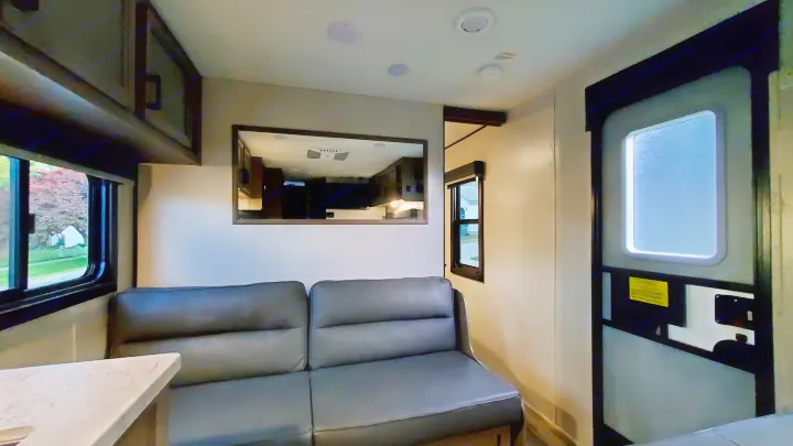 RV rental interior: comfy sofa, dinette, large mirror, and bright windows provide a welcoming space.. Starcraft Autumn Ridge 2022