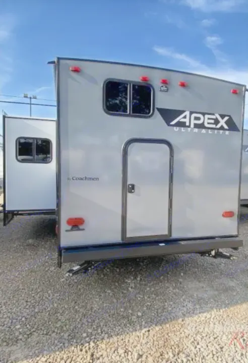 Rear view of a gray Coachmen Apex Ultralite travel trailer, ideal for an RV rental adventure, with a slide-out.. Coachmen Other 2022