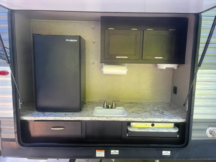 This RV rental features a convenient outdoor kitchen with a compact fridge, sink, and pull-out cooktop.. Jayco Jay Flight 2021