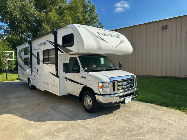 This bright white Forester RV rental is parked on a concrete driveway, ready for your next adventure.. Forester LE 2018