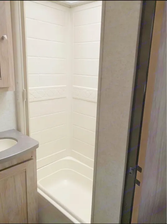 This RV rental features a clean, compact bathroom with a white shower/tub unit and an adjacent sink vanity.. Forester LE 2018