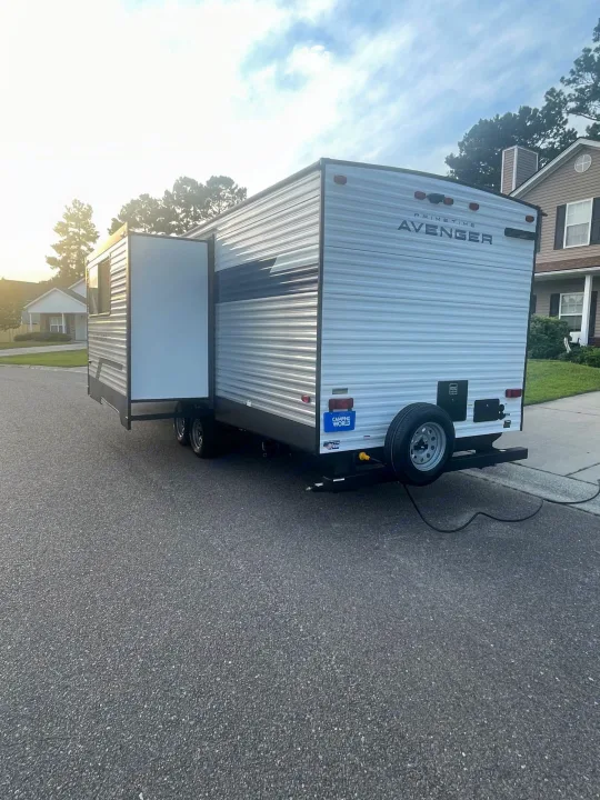 This RV rental, a Prime Time Avenger travel trailer, is parked with its slide-out extended, ready for adventures.. Forest River Prime time Avenger 2023