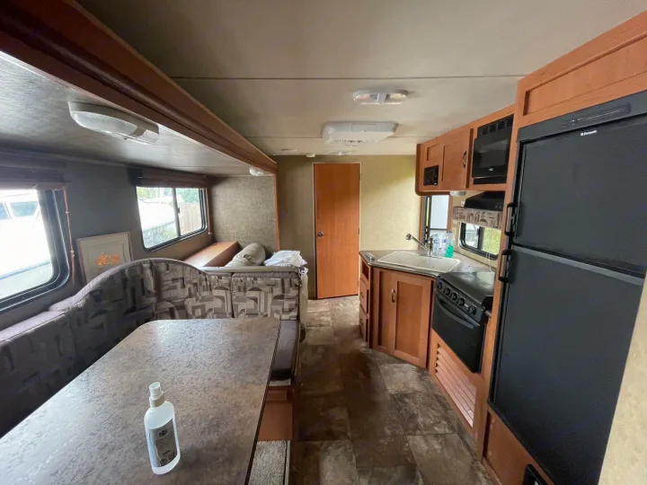 RV rental interior: dining booth with table, plus full kitchen with appliances.. Forest River Cherokee Grey Wolf 2015