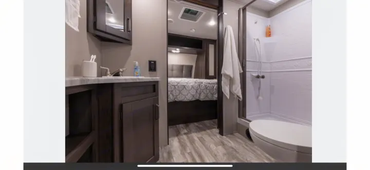 RV rental: View of an RV's modern bathroom with sink, shower, toilet, and a peek into the bedroom.. Grand Design Transcend Xplor 2021