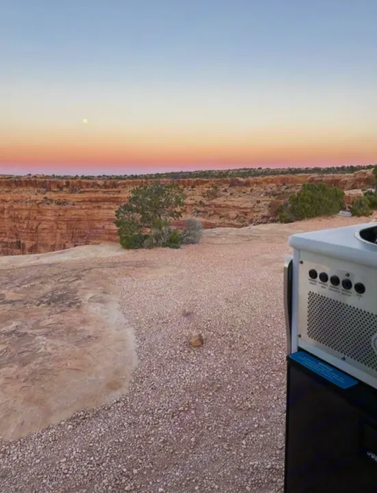 Stunning desert canyon vista at sunset with a moon, seen from an RV rental. Perfect for outdoor adventure travel.. Mercedes-Benz sprinter 2023