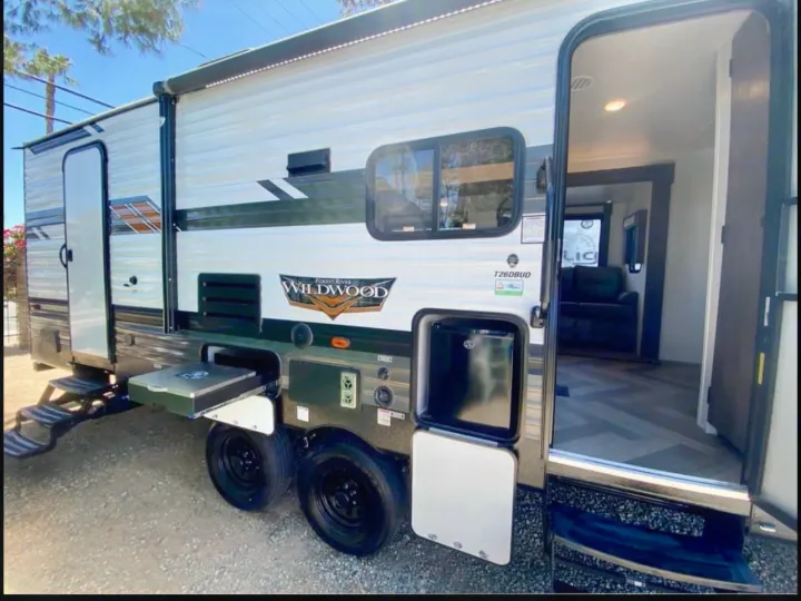 Wildwood RV rental with outdoor kitchen, steps down. Interior view shows herringbone floor & sofa. Perfect for travel!. Forest River Wildwood 2021