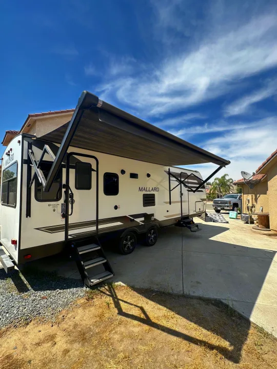 White Mallard travel trailer with extended awning & steps, parked on a driveway. Ideal for rv rental.. Heartland Other 2021