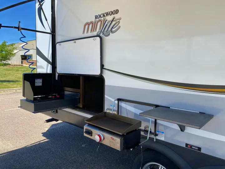 RV rental with convenient outdoor kitchen! Features a pull-out stove, griddle, and fold-down table, perfect for camping.. Forest River Rockwood Mini Lite 2021