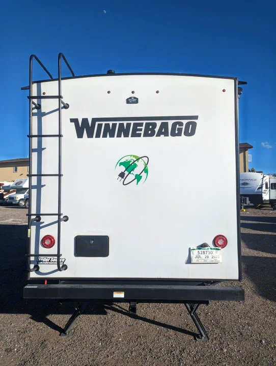 Rear view of a white Winnebago camper trailer with a ladder and outdoor shower, ideal for your next RV rental.. Winnebago Micro Minnie 2022