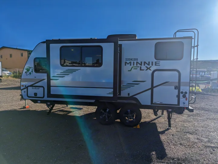 White Micro Minnie FLX travel trailer parked under a clear sky. Consider this RV rental for your next camping trip.. Winnebago Micro Minnie 2022