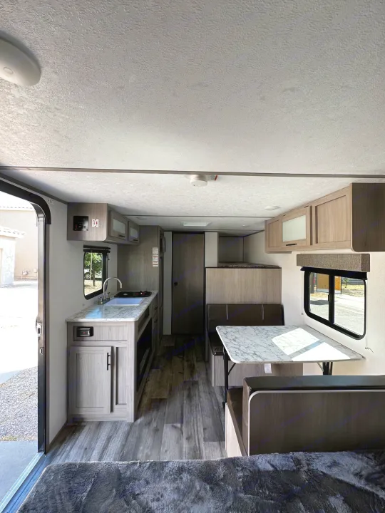 Spacious modern RV rental interior with kitchen, dining, and bunks. Ready for your next adventure!. Dutchmen Coleman Lantern LT 2023