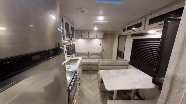 Modern RV rental interior with a fully equipped kitchen, comfortable living area, and bright dinette. Ideal for travel.. East to West Della Terra 2023