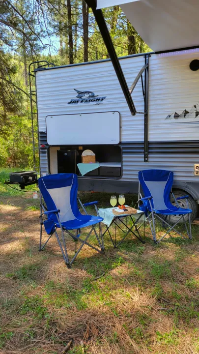 RV rental setup: outdoor kitchen, grill, awning, and chairs for relaxation amidst nature. Enjoy camping!. Jayco Jay Flight 2023